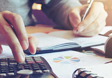 Close up hand man doing finance and calculate on desk about cost at home office.